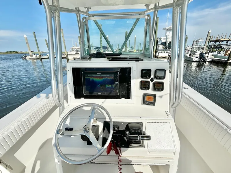 Slide: The Image of 2006 Regulator 32 FS boat console with steering wheel and navigation equipment at marina. - 16