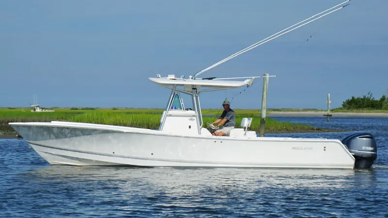 Slide: The Image of 2006 Regulator 32 FS boat on calm water with scenic background. - 4
