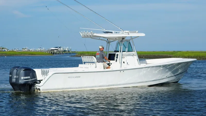 Slide: The Image of 2006 Regulator 32 FS boat on water with dual Yamaha engines, clear sky background. - 5