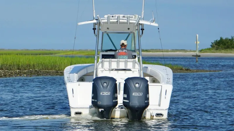 Slide: The Image of 2006 Regulator 32 FS boat with dual Yamaha engines navigating a waterway. - 7