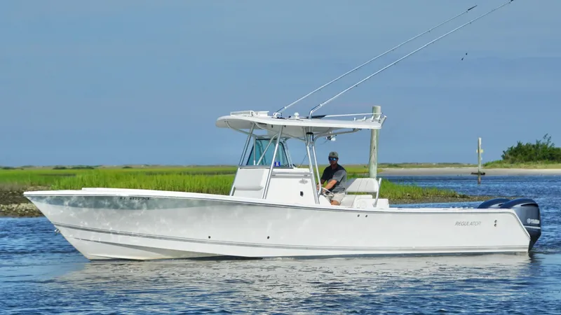 Slide: The Image of 2006 Regulator 32 FS boat cruising on calm water with a person at the helm. - 9