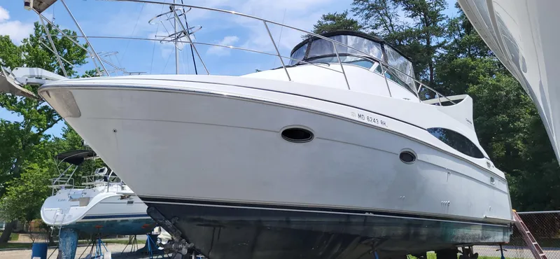 Slide: The Image of 2000 Carver 350 Mariner yacht on dry dock, surrounded by trees and clear sky. - 1