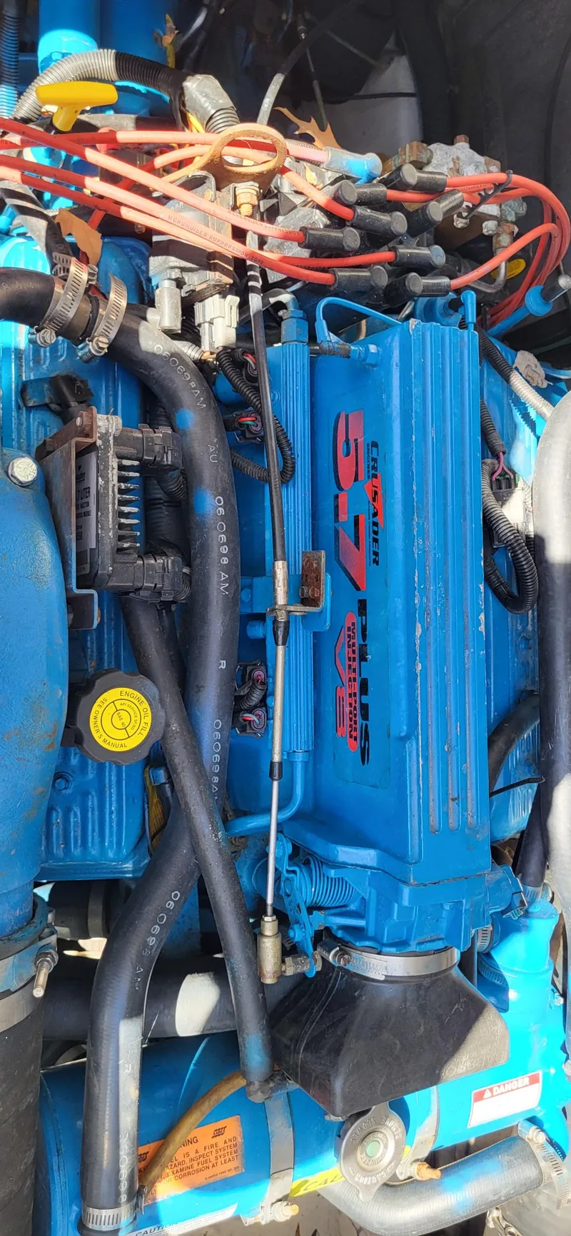 Slide: The Image of Close-up of a 2000 Carver 350 Mariner engine, featuring blue components and red wiring. - 12