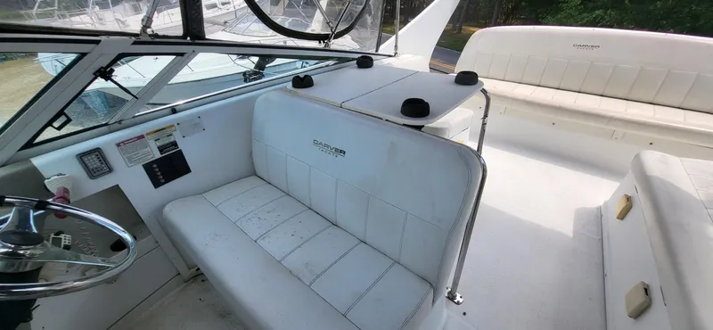 Slide: The Image of 2000 Carver 350 Mariner boat interior with white seating and steering wheel. - 18