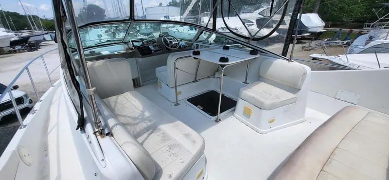 Slide: The Image of 2000 Carver 350 Mariner boat interior with seating and helm, docked among other boats. - 22