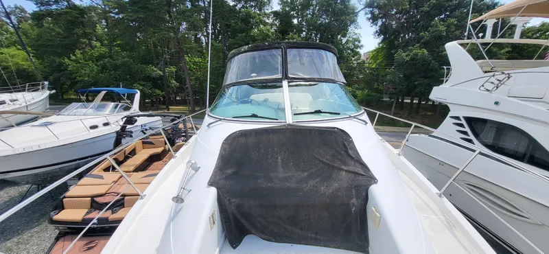 Slide: The Image of 2000 Carver 350 Mariner yacht docked among other boats, surrounded by lush greenery. - 25