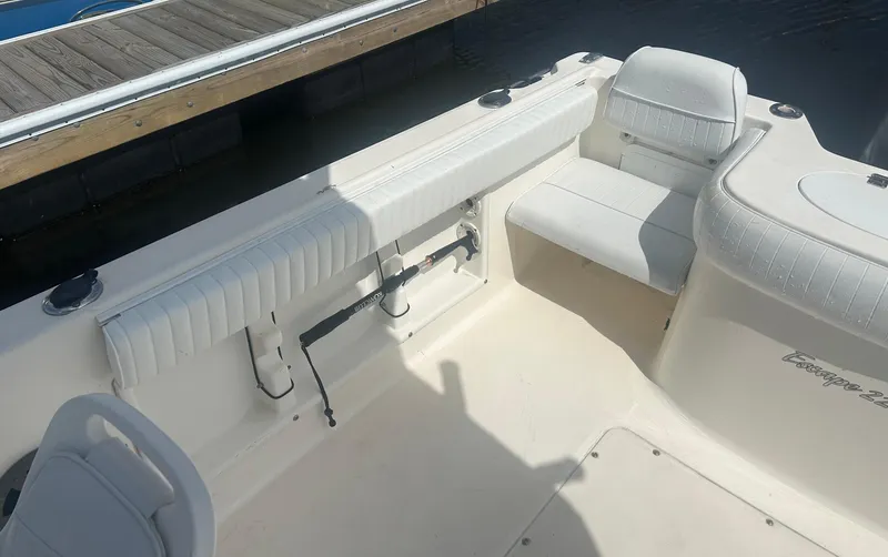 Slide: The Image of 2005 Sea Hunt Escape 220 boat interior with white seating and dockside view. - 3