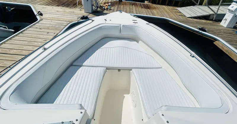 Slide: The Image of 2005 Sea Hunt Escape 220 boat with white cushioned seating at dock. - 7