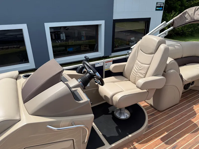 Slide: The Image of 2018 SunCatcher Elite 322 RC boat interior with beige captain's chair and steering console. - 12