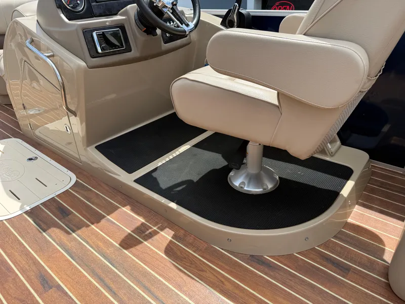Slide: The Image of Captain's chair and console of 2018 SunCatcher Elite 322 RC boat, featuring wood-style flooring. - 13