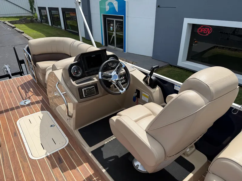 Slide: The Image of 2018 SunCatcher Elite 322 RC boat interior with beige seating and modern dashboard. - 14