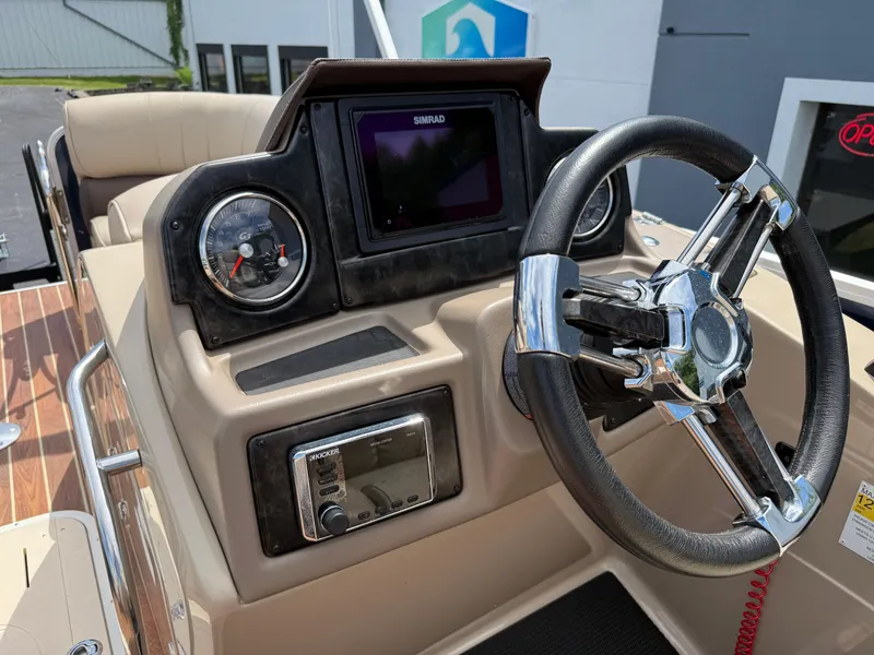 Slide: The Image of 2018 SunCatcher Elite 322 RC boat dashboard with steering wheel and navigation controls. - 15