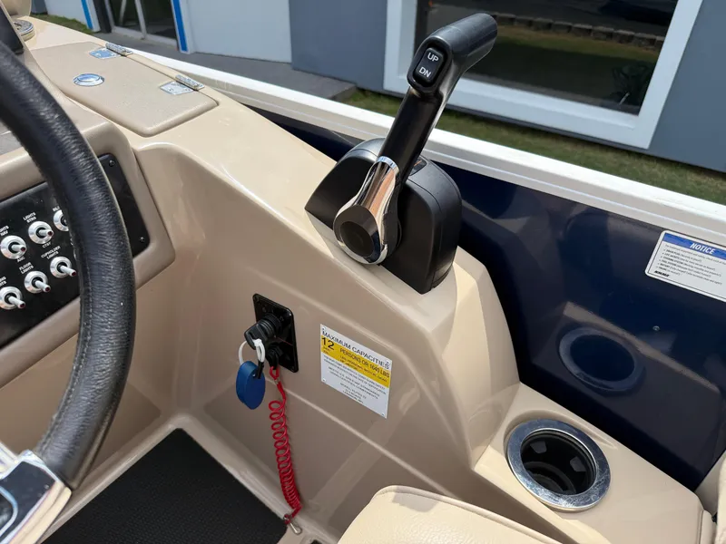 Slide: The Image of 2018 SunCatcher Elite 322 RC boat controls with throttle, cup holder, and safety lanyard. - 18