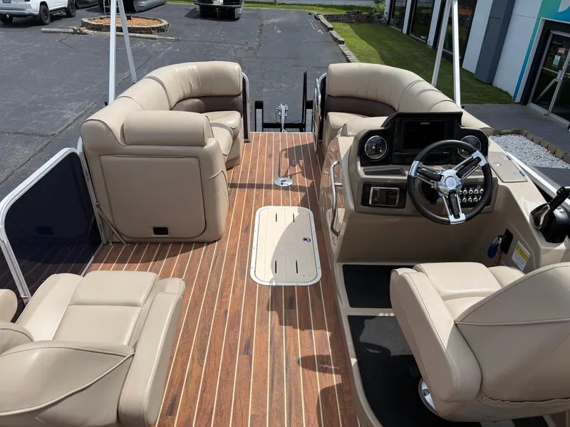 Slide: The Image of 2018 SunCatcher Elite 322 RC pontoon boat interior with beige seating and wood-style flooring. - 24