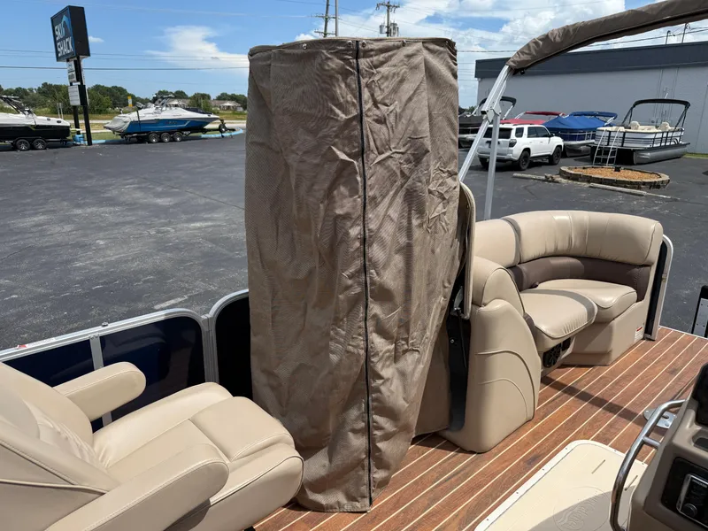 Slide: The Image of 2018 SunCatcher Elite 322 RC pontoon boat interior with beige seating and protective cover. - 26