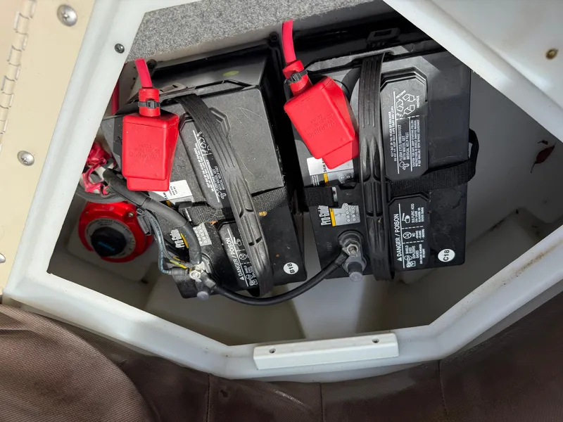 Slide: The Image of 2018 SunCatcher Elite 322 RC boat battery compartment with dual batteries and red connectors. - 27