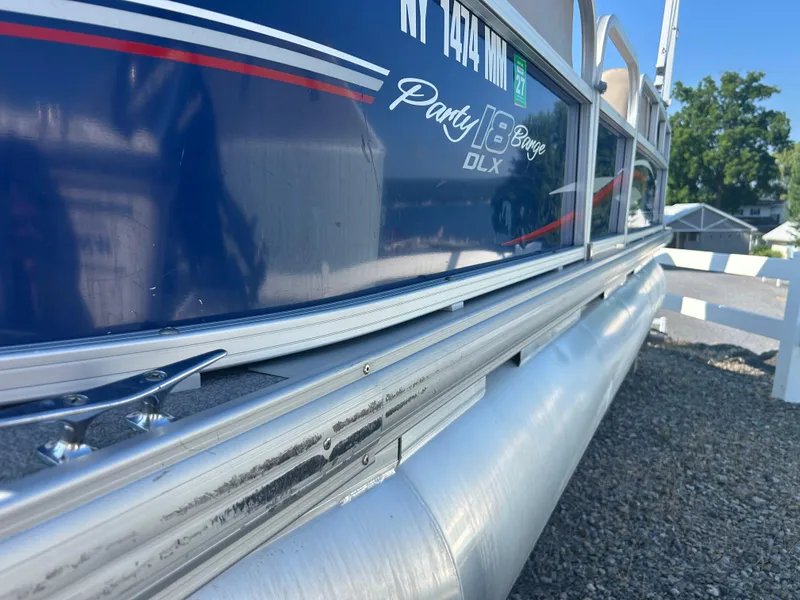 Slide: The Image of 2016 Sun Tracker Party Barge 18 DLX pontoon boat, side view with blue and silver detailing. - 11
