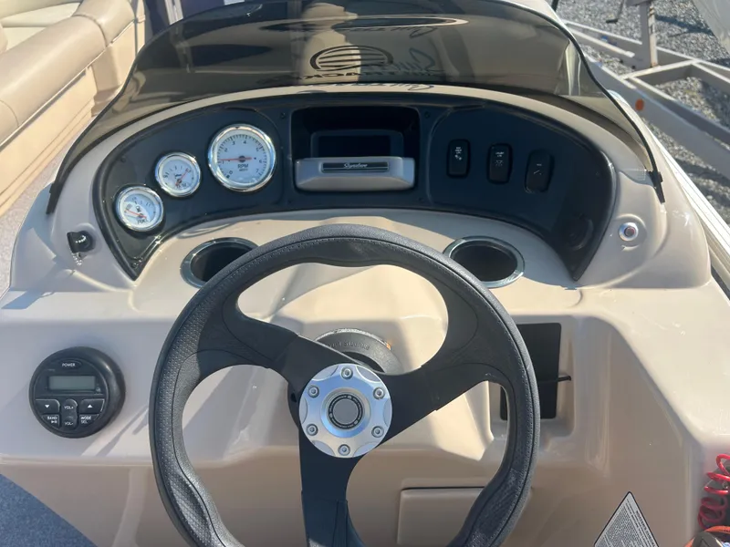 Slide: The Image of 2016 Sun Tracker Party Barge 18 DLX dashboard with steering wheel and gauges. - 15