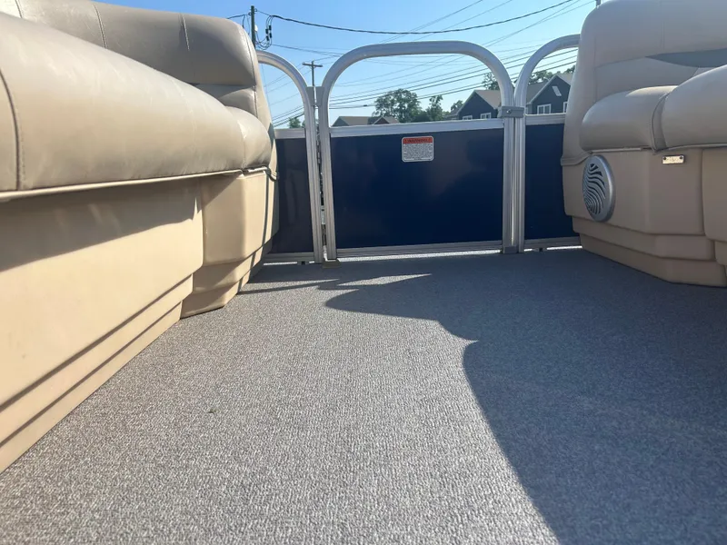 Slide: The Image of 2016 Sun Tracker Party Barge 18 DLX interior with beige seating and carpeted floor. - 24