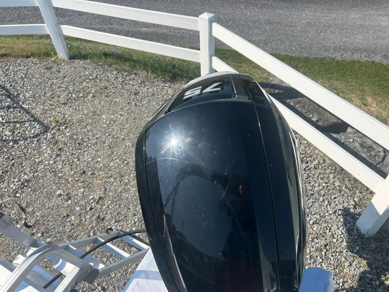 Slide: The Image of Outboard motor on a 2016 Sun Tracker Party Barge 18 DLX, parked on gravel. - 27