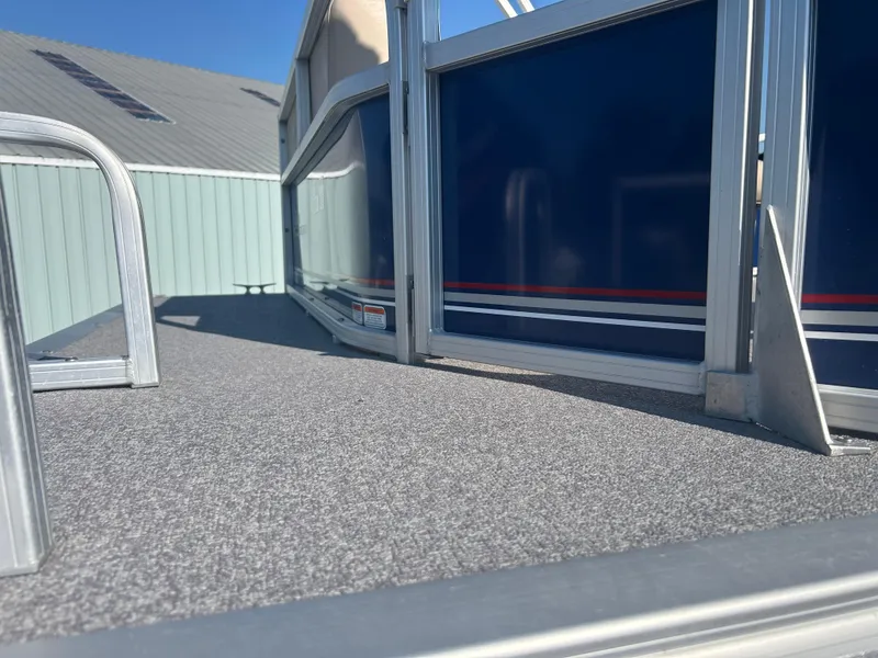 Slide: The Image of 2016 Sun Tracker Party Barge 18 DLX deck with blue paneling and metal railing. - 29