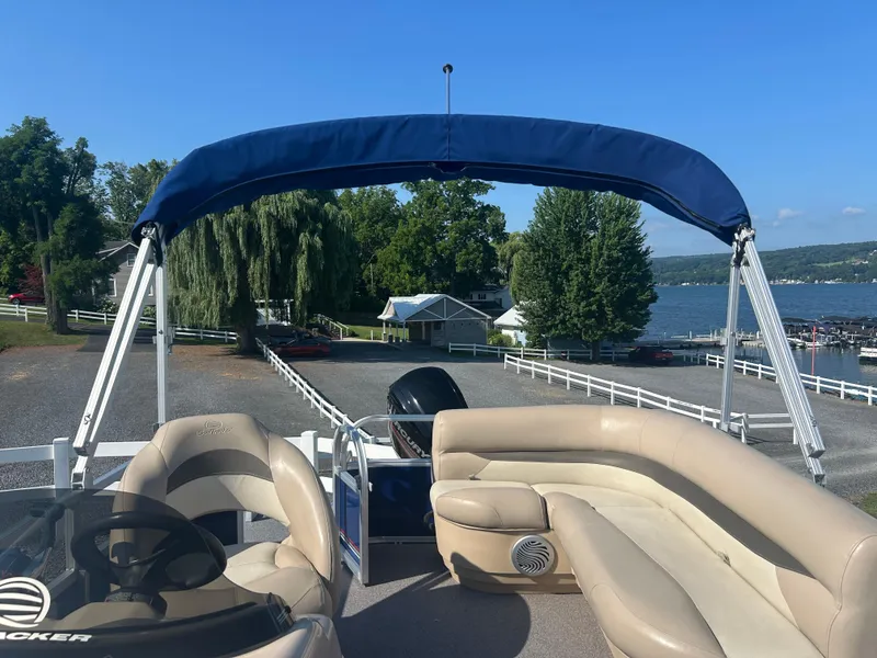 Slide: The Image of 2016 Sun Tracker Party Barge 18 DLX pontoon boat with canopy, near a scenic lakeside. - 7
