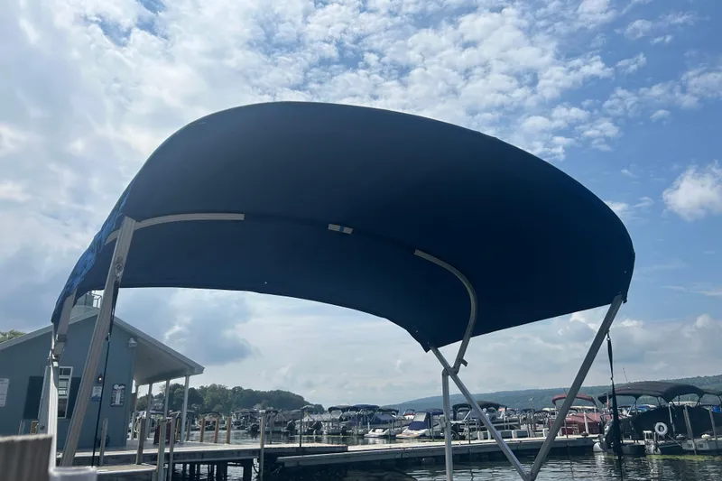 Slide: The Image of Blue canopy of a 2016 Sun Tracker Party Barge 18 DLX at a marina. - 8