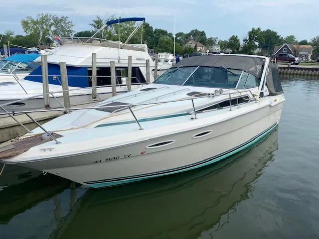 The Image of 1987 Sea Ray 300 Weekender boat docked in a marina, surrounded by other vessels. - 0