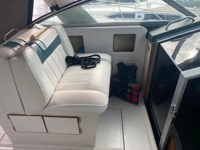 Slide: The Image of 1987 Sea Ray 300 Weekender interior with white seating and life jackets. - 10