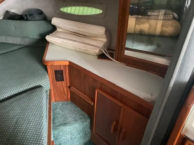 Slide: The Image of 1987 Sea Ray 300 Weekender cabin interior with wood cabinetry and green upholstery. - 18
