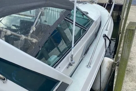 Slide: The Image of 1987 Sea Ray 300 Weekender boat docked, featuring sleek design and spacious cockpit. - 2