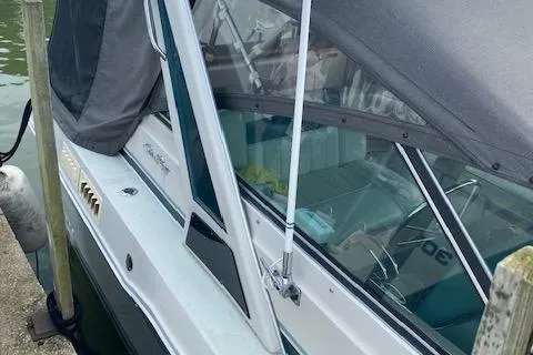 Slide: The Image of 1987 Sea Ray 300 Weekender boat docked, featuring a covered cabin and sleek design. - 3