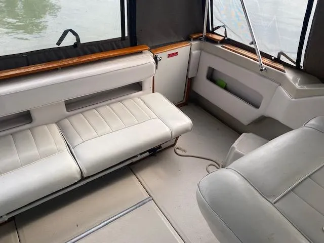 Slide: The Image of 1987 Sea Ray 300 Weekender interior with white seating and wood accents. - 7