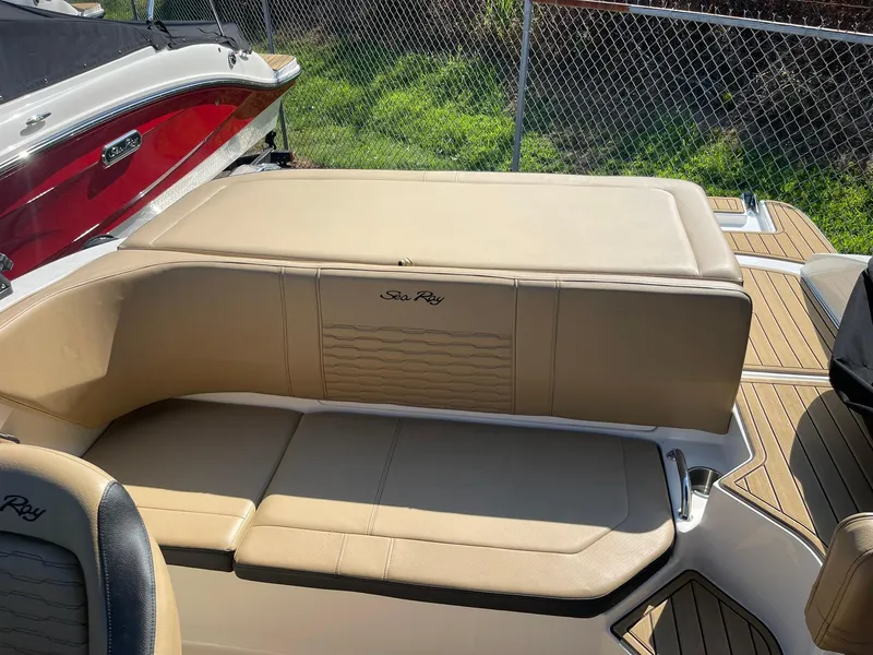 Slide: The Image of 2023 Sea Ray SPX 190 boat interior with beige seating and wood accents. - 5