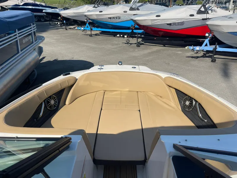 Slide: The Image of 2023 Sea Ray SPX 190 boat interior with tan seating, docked among other boats. - 8