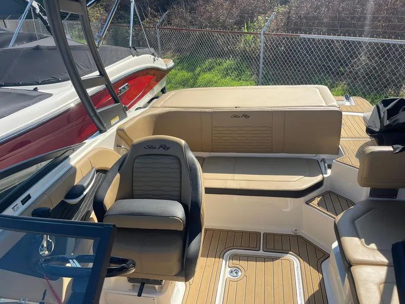 Slide: The Image of 2023 Sea Ray SPX 190 boat interior with tan seating and steering wheel. - 9
