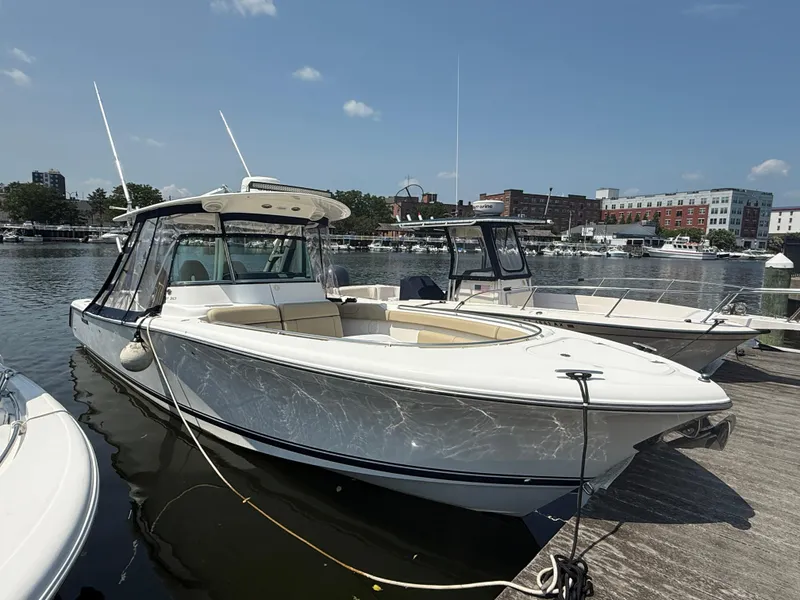 The Image of 2015 Pursuit ST 310 Sport boat docked at marina under clear sky. - 0
