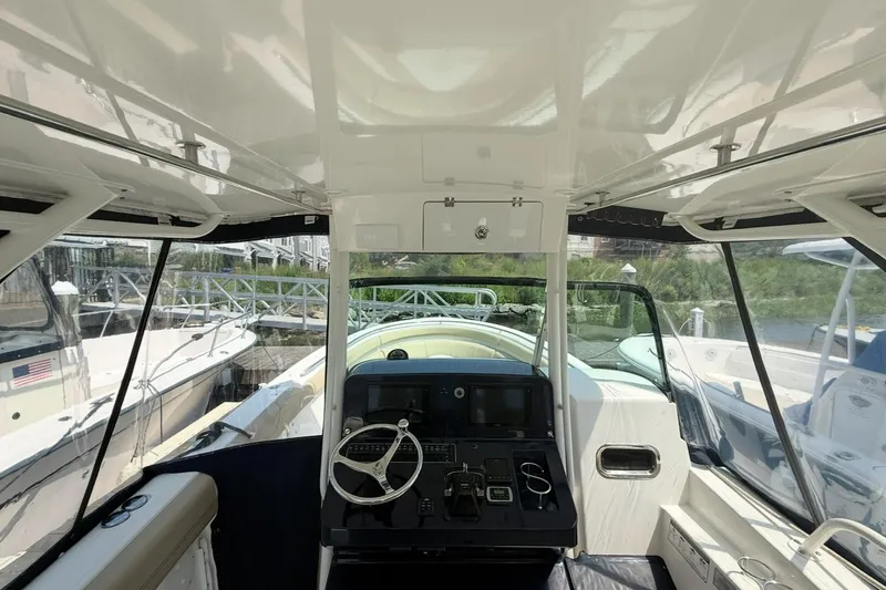 Slide: The Image of 2015 Pursuit ST 310 Sport boat interior with steering wheel and control panel. - 10
