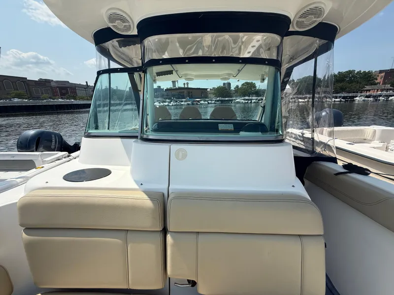 Slide: The Image of 2015 Pursuit ST 310 Sport boat with beige seating, docked at a marina. - 15