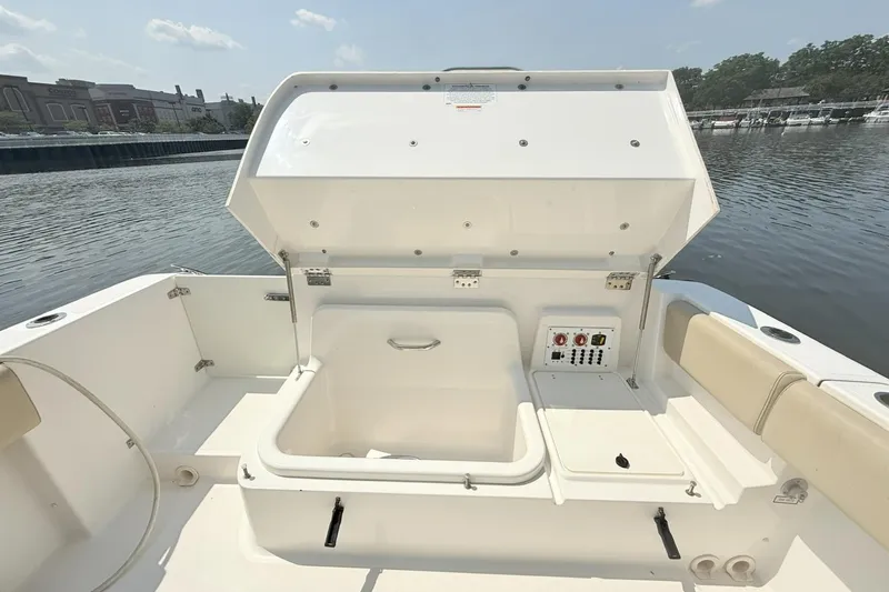 Slide: The Image of 2015 Pursuit ST 310 Sport boat with open storage compartment by the water. - 18