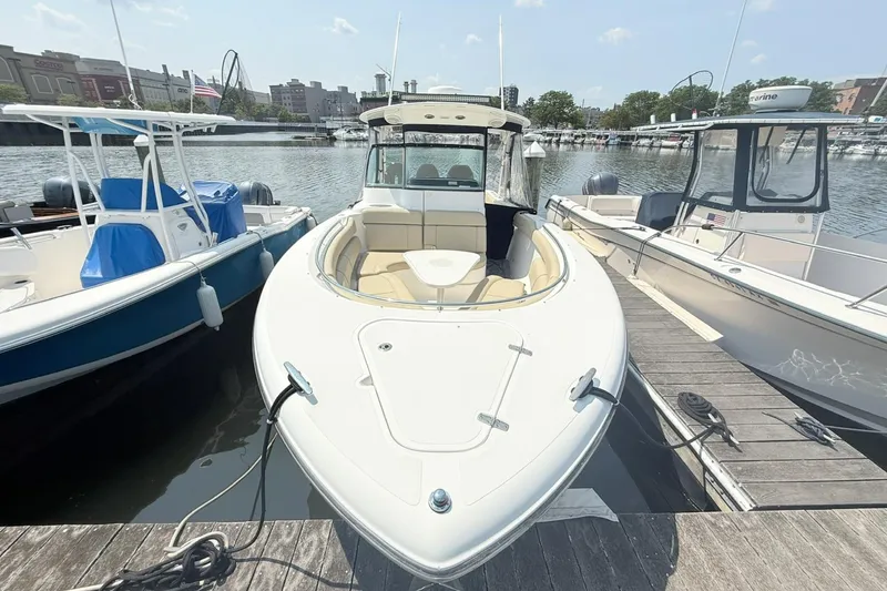 Slide: The Image of 2015 Pursuit ST 310 Sport boat docked at marina, surrounded by other boats. - 2