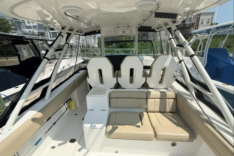 Slide: The Image of 2015 Pursuit ST 310 Sport boat interior with seating and helm, docked at marina. - 7