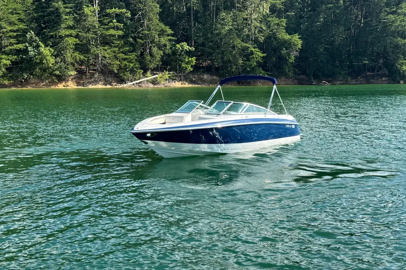 Slide: The Image of 2006 Cobalt 240 boat on a serene lake with lush forest background. - 14