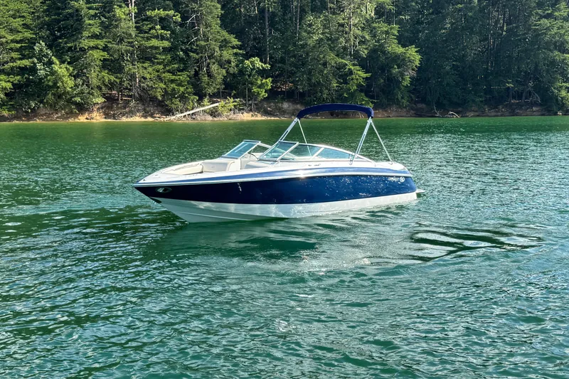 Slide: The Image of 2006 Cobalt 240 boat on a serene lake with lush forest background. - 15