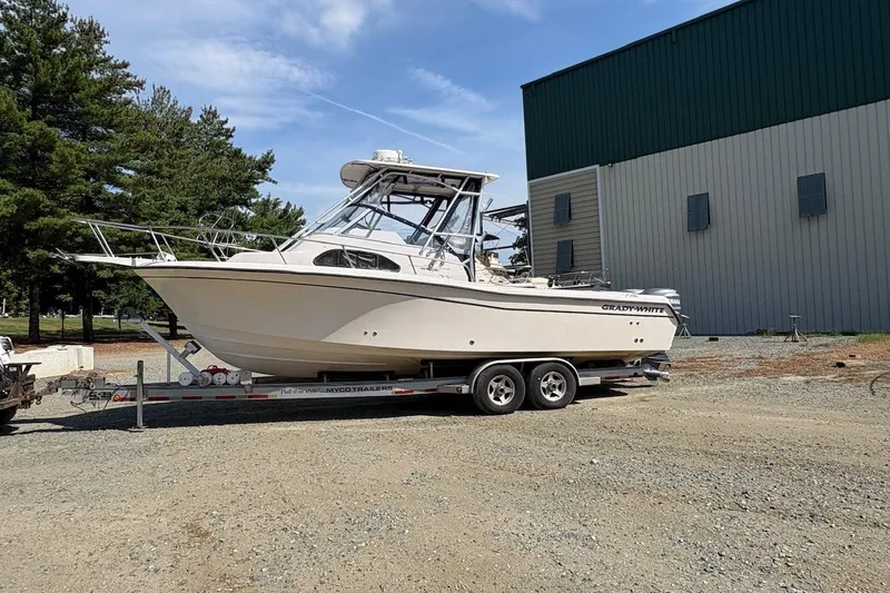 The Image of 2003 Grady-White Sailfish 282 boat on trailer, parked outdoors near building. - 0