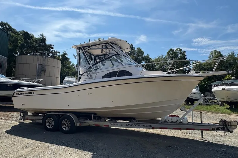 Slide: The Image of 2003 Grady-White Sailfish 282 boat on trailer, parked outdoors under blue sky. - 2