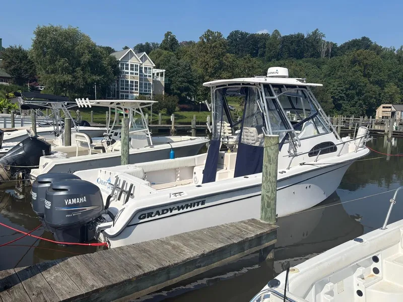 Slide: The Image of 2003 Grady-White Sailfish 282 boat docked with Yamaha engines, surrounded by lush greenery. - 5
