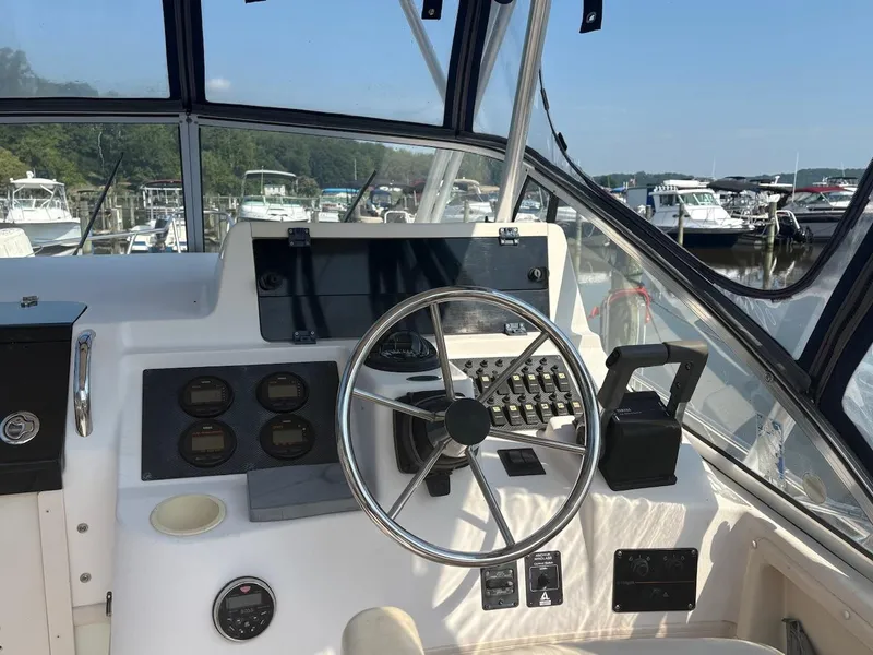 Slide: The Image of 2003 Grady-White Sailfish 282 helm with steering wheel and control panel at marina. - 6