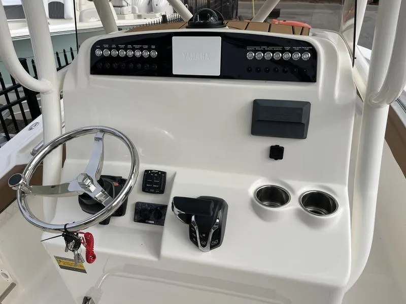 Slide: The Image of 2026 Pioneer 222 Islander boat console with steering wheel, controls, and cup holders. - 11