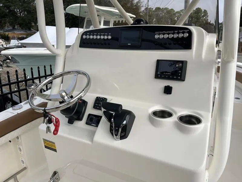 Slide: The Image of 2026 Pioneer 222 Islander boat console with steering wheel, controls, and cup holders. - 12